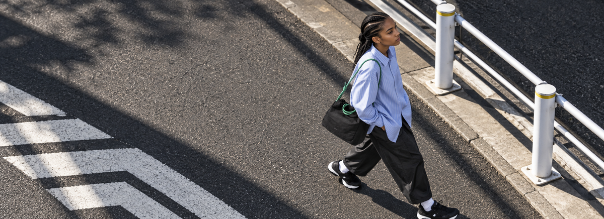 A person carrying a ScandiHome bag across a city street