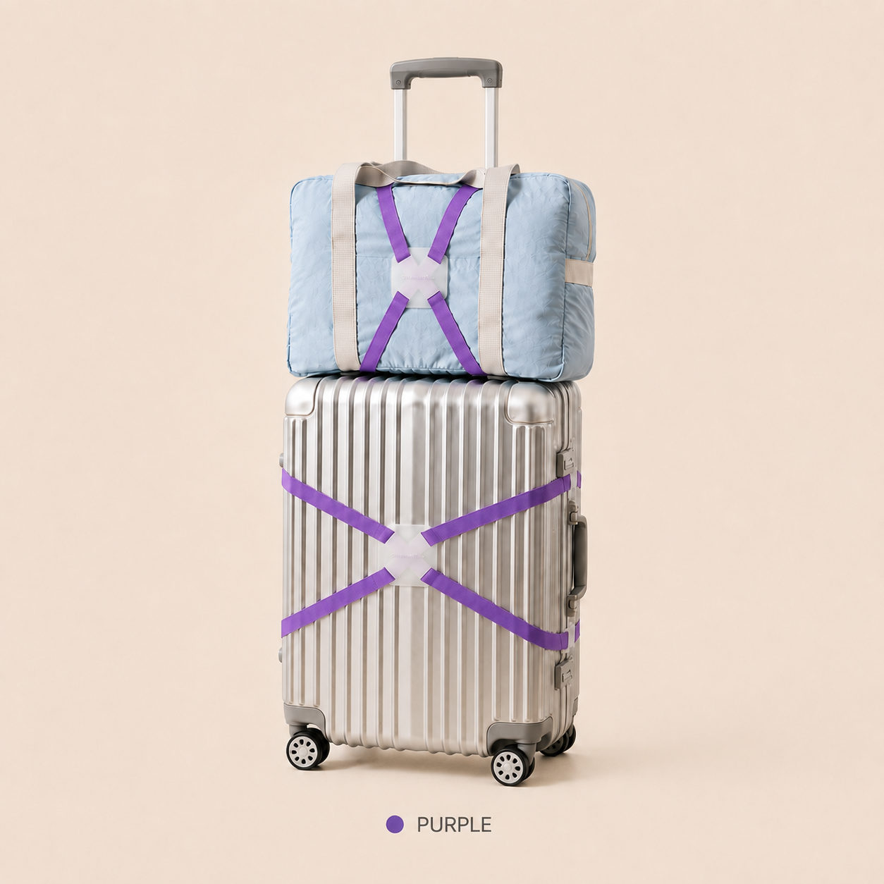 ScandiHome purple X-cross luggage strap securing a silver suitcase and travel bag