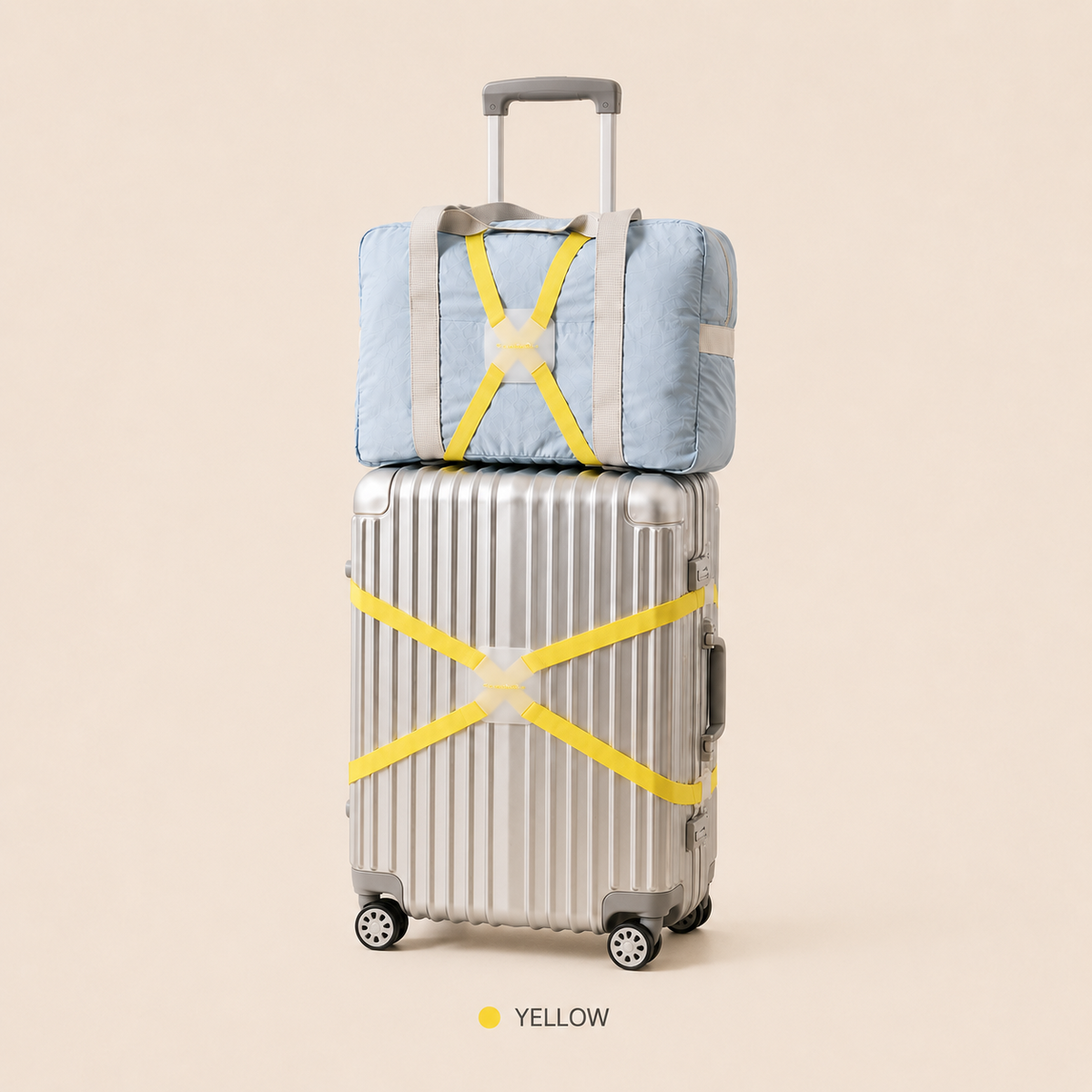 ScandiHome yellow X-cross luggage strap securing a silver suitcase and travel bag